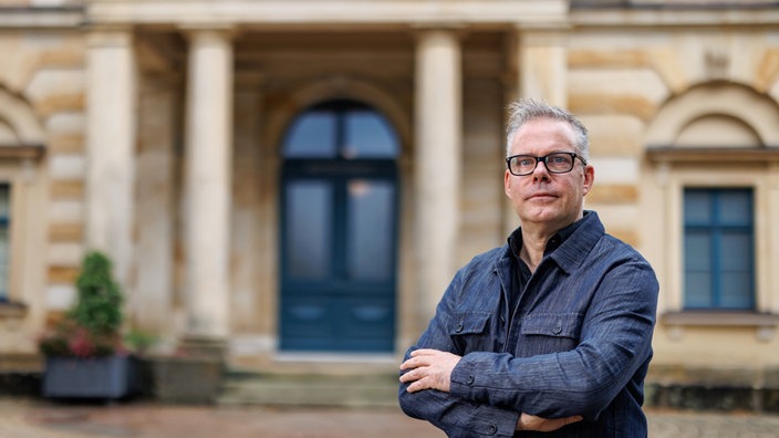 Marcus Lobbes, Direktor der Akademie für Theater und Digitalität in Dortmund, steht vor dem Festspielhaus in Bayreuth.