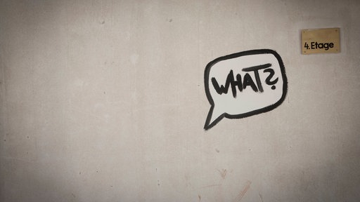 Das Graffito einer Sprechblase mit der Inschrift "What?" an einer Wand.