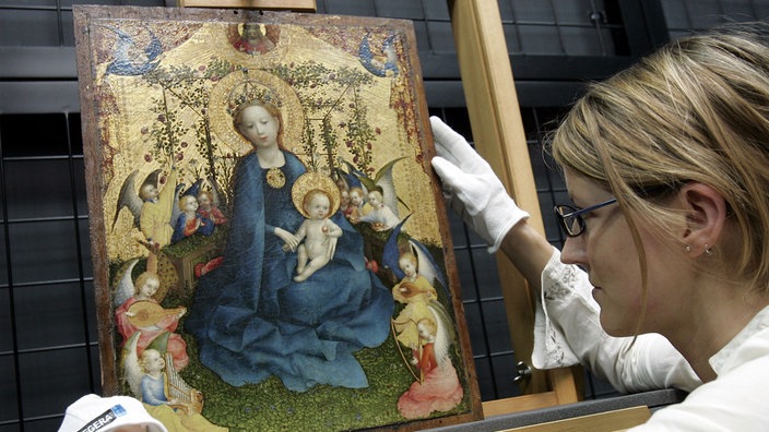 Archivaufnahme von 2006: Das Werk "Muttergottes in der Rosenlaube" des Künstlers Stefan Lochner wird von einer Mitarbeiterin des Wallraff-Richartz-Museums auf eine Staffelei gestellt. 
