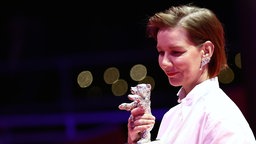 Sandra Hüller zeigt ihre Auszeichnung, den Silbernen Bären für die beste schauspielerische Leistung in einer Hauptrolle im Film "Rose" nach der Preisverleihung bei der Abschlussgala im Berlinale Palast am 21.02.2026.