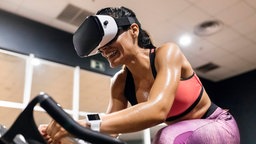 Eine Frau trägt beim Spinning eine VR-Brille