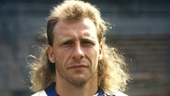 Wolfgang Rolff 1993 mit ernstem Blick und langen Haaren im Trikot des Karlsruher SC
