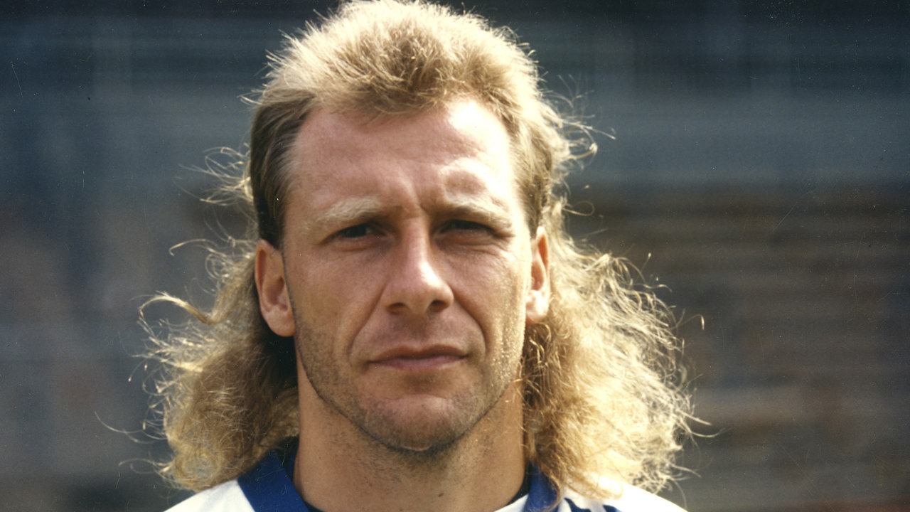 Wolfgang Rolff 1993 mit ernstem Blick und langen Haaren im Trikot des Karlsruher SC