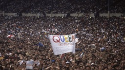 Queen Live at Wembley Stadium, 11th July 1986, Blick in die Masse, die ein Transparent mit der Aufschrift "Queen" hochhält