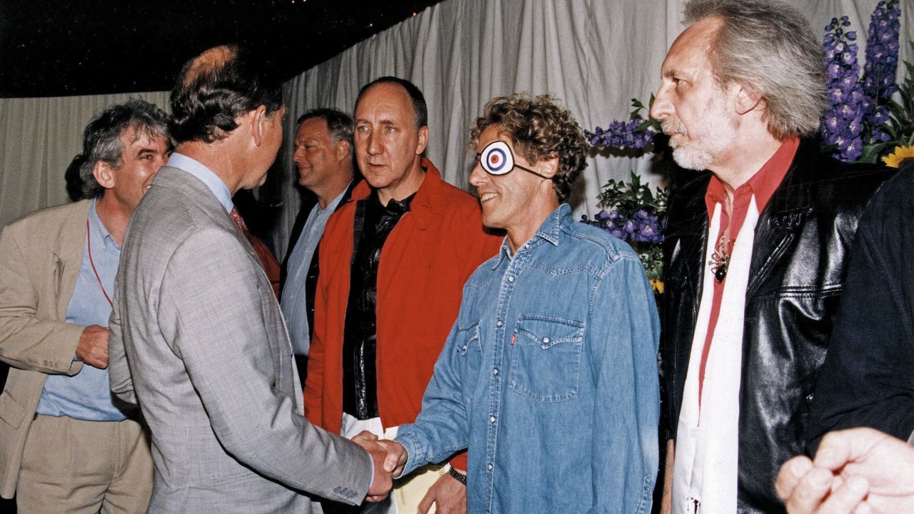 Prinz Charles gibt Roger Daltrey bei einem Treffen mit der Band die Hand.