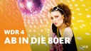 Eine im Stil der 80er Jahre gekleidete Frau mit Sonnenbrille, wilden Haaren, Kette, Schweißband und Kopfhörer schaut in die Kamera. Im Hintergrund dreht sich eine Discokugel