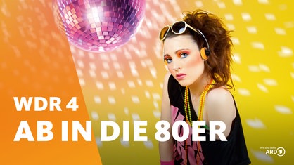 Eine im Stil der 80er Jahre gekleidete Frau mit Sonnenbrille, wilden Haaren, Kette, Schweißband und Kopfhörer schaut in die Kamera. Im Hintergrund dreht sich eine Discokugel