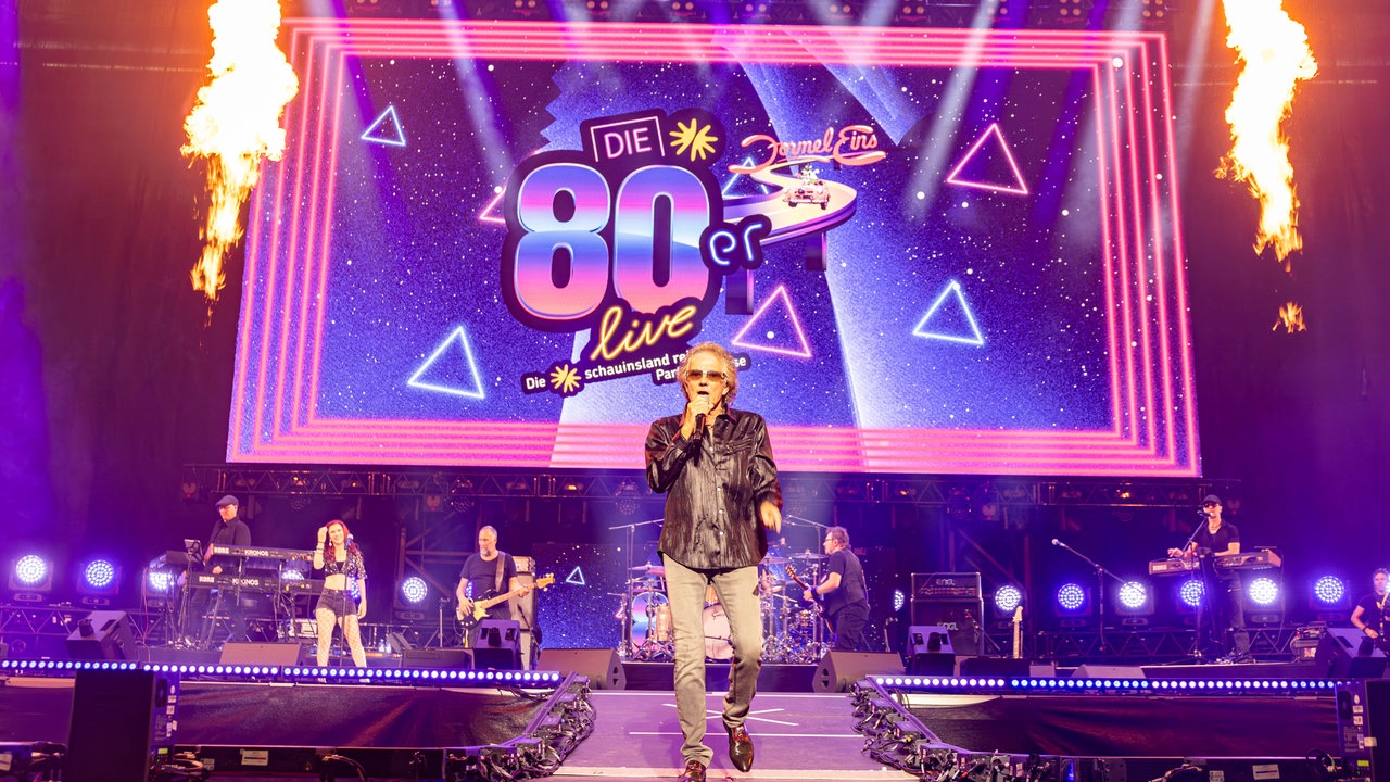Mickey Thomas von der Band Starship singt neben Feuerwerk auf der Bühne