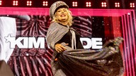 Die britische Popsängerin Kim Wilde steht auf der Bühne und singt in einem silbernen Glitzerkleid