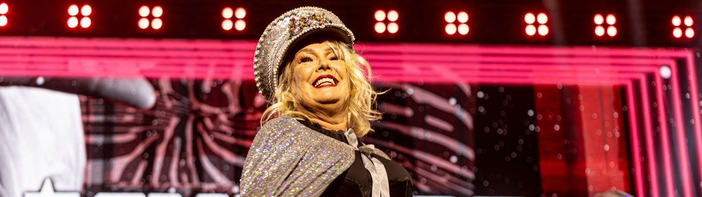 Die britische Popsängerin Kim Wilde steht auf der Bühne und singt in einem silbernen Glitzerkleid