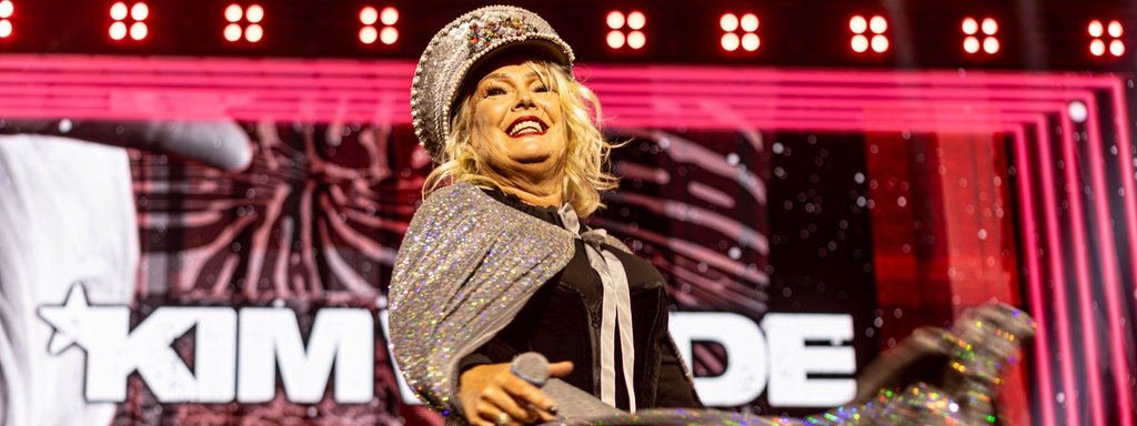 Die britische Popsängerin Kim Wilde steht auf der Bühne und singt in einem silbernen Glitzerkleid