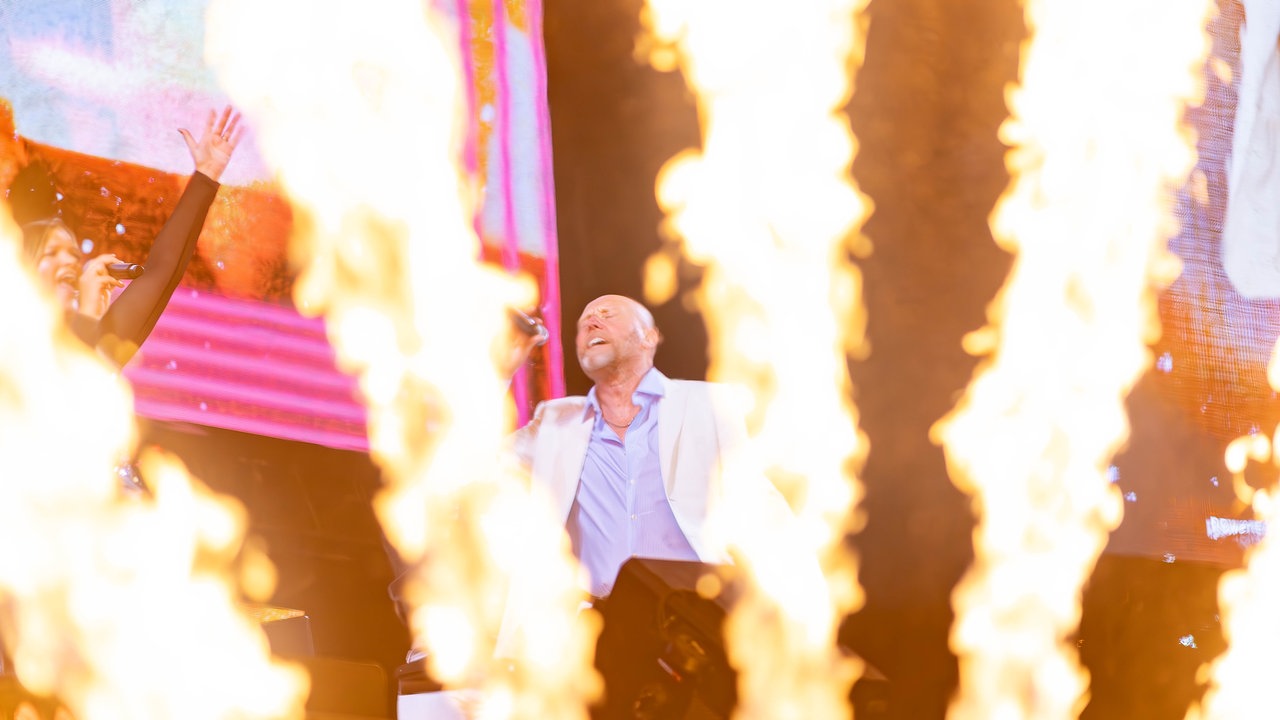Die Band Heaven 17 steht vor Feuerwerk und singt 