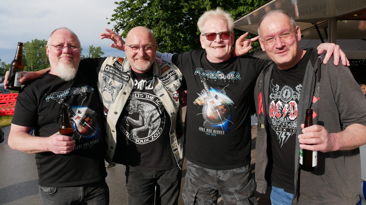 Vier männliche Fans mit Band-T-Shirts