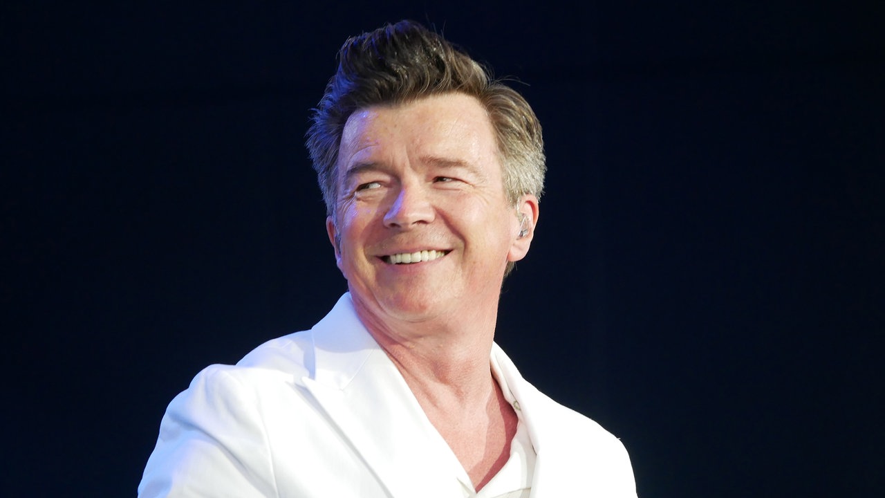 Rick Astley lächelnd auf der Bühne