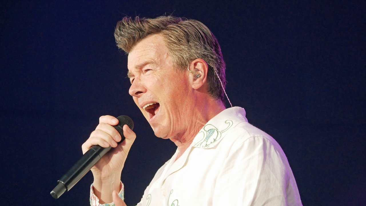 Rick Astley singt ins Mikro