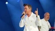 Rick Astley mit erhobenem Finger