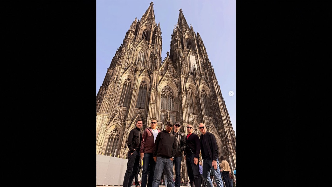 Vor dem Kölner Dom stehen Mitglieder von UB 40
