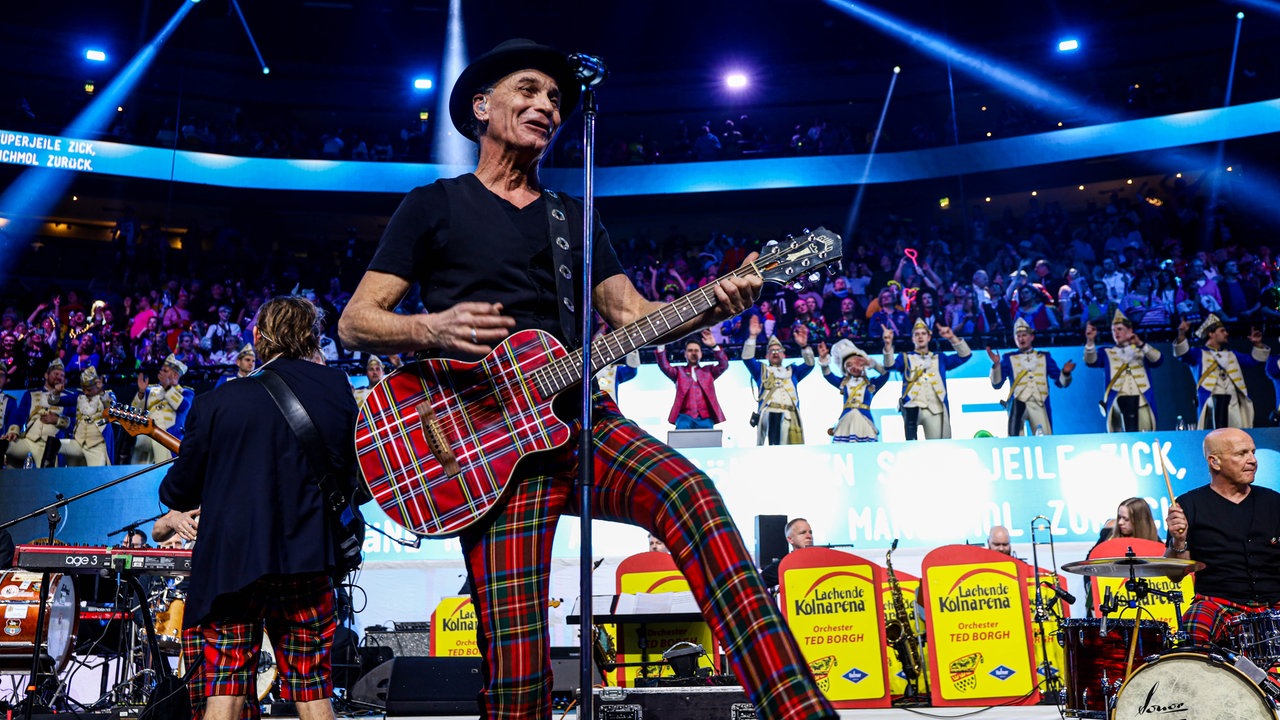 Lachende Köln Arena 2026: Peter Brings steht mit Gitarre auf der Bühne und singt