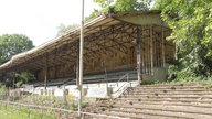 Eine ältere, bereits von Pflanzen leicht überwachsene Tribüne