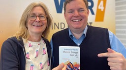 Ute Schneider und Mike Altwicker präsentieren das Buchcover: "Meine Berge bist du" von Francesco Vidotto
