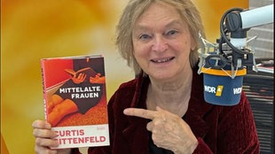 Elke Heidenreich hält das Buchcover: "Mittelalte Frauen" von Curtis Sittenfeld in die Kamera