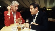 Diether Krebs und Rudi Carrell mit Kölsch am Tisch stehend 