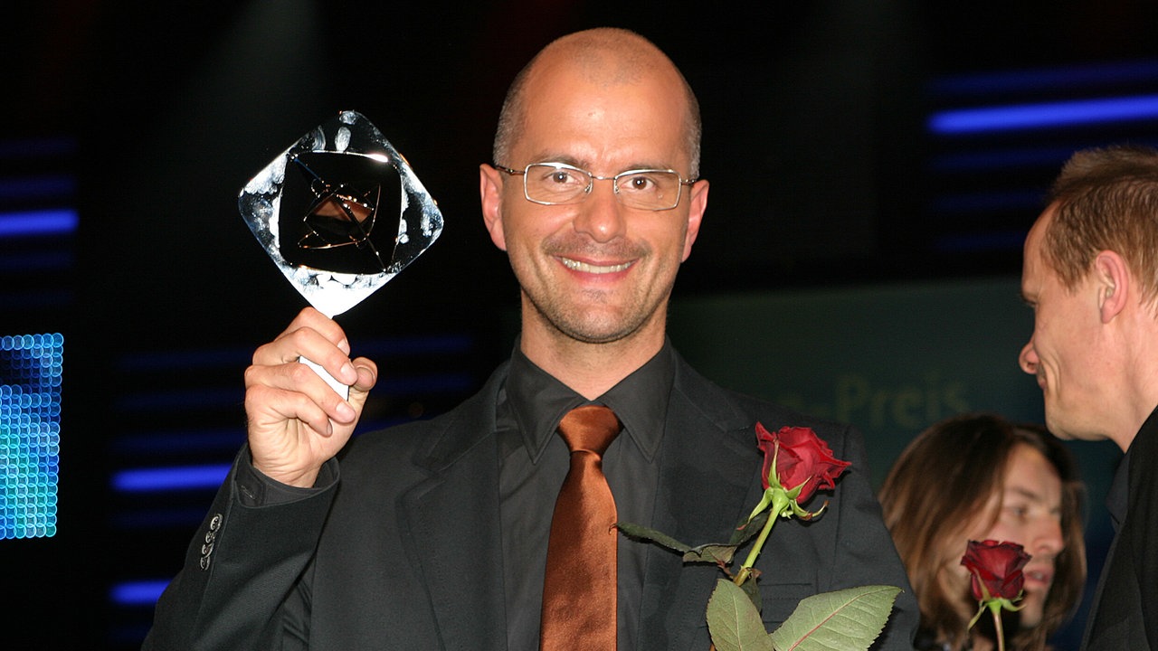 Christoph Maria Herbst 2006 mit dem Grimmepreis und einer Rose in der Hand
