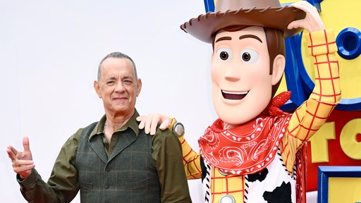 Tom Hanks im Mai 2026 neben Cowboy Woody beim Launch Event zu Toy Story 5 in Großbritannien