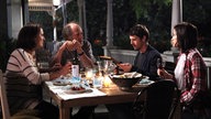 Szene aus dem Film "Die kanadische Reise": Die Familie Pierres sitzt mit Mathieu an einem gedeckten Esstisch.