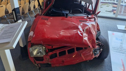 Kaputtes, altes, rotes Auto mit vielen Dellen