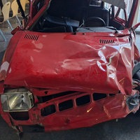Kaputtes, altes, rotes Auto mit vielen Dellen