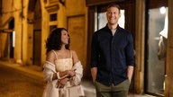 Eine Szene des Films "Love in the Villa": Julie (Kat Graham) und Charlie (Tom Hopper) spazieren abends durch die Straßen von Verona. Julie schaut Charlie an, beide lächeln.