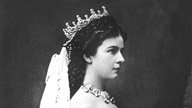 Gemälde von Sisi im Krönungsornat als Königin von Ungarn. Das Gemälde zeigt sie im Profil, ihr Blick ist ernst.