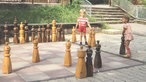 Zwei Kinder spielen mit den Figuren eines Riesenschachspiels (1977)