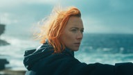 Eine Szene des Films "The Outrun": Saoirse Ronan mit roten Haaren als Rona vor einem stürmischen Meer