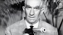 Szene aus dem Spielfilm "Fantomas": Inspektor Juve (Louis de Funès) hält einen Revolver in der Hand