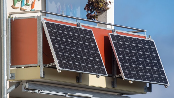 Solarmodule für ein Balkonkraftwerk hängen an einem Balkon