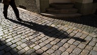 Der Schatten einer Person in einer dunkeln Straße. Geheimnisvolle Atmosphäre. 