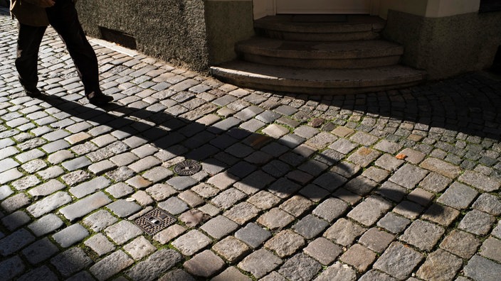 Der Schatten einer Person in einer dunkeln Straße. Geheimnisvolle Atmosphäre. 