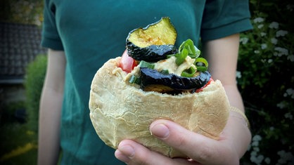 Pita mit gegrilltem Gemüse und Hummus gefüllt