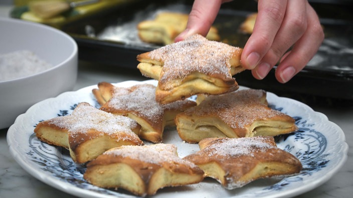 Sternförmige Weihnachtsweckchen sind auf einem Teller angerichtet