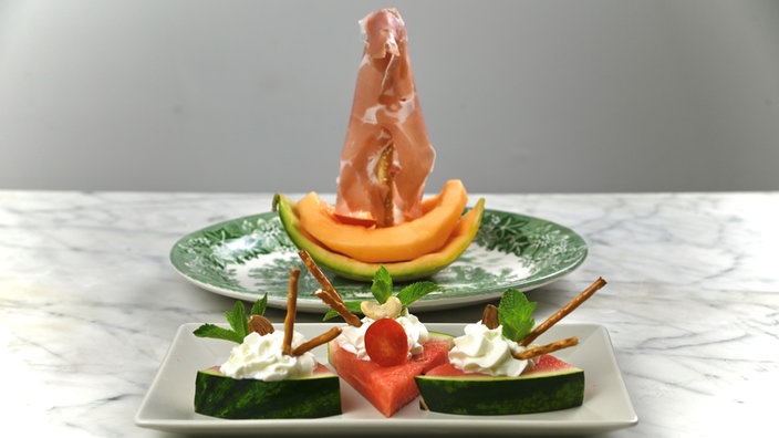 Honigmelone mit Shcinkenscheiben und Wassermelone mit Fetacreme und Basilikum verziert