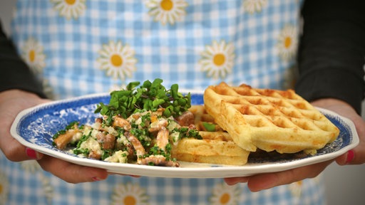 Ein angerichteteter Teller mit zwei Waffeln und einer Portion Pfifferlingen.