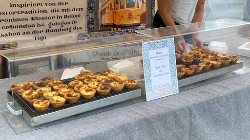 Ein Stand auf dem Ökomarkt Südstern. In der Auslage sind portugiesische Pastéis de Nata zu sehen. 