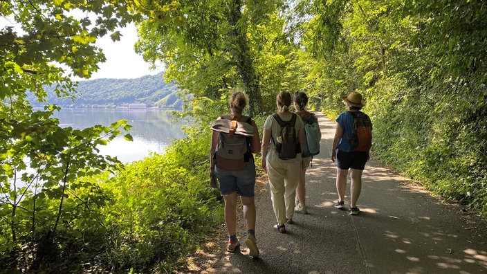Auf "Wein-Jagd" am Hengsteysee: Vier Wanderer am Ufer des Sees
