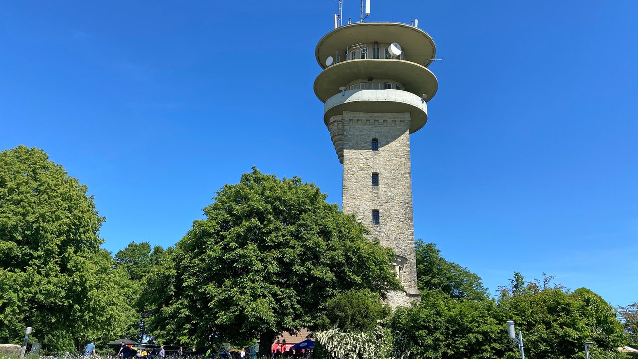 Durch die Baumberge: Ein Turm mit Bäumen unterhalb mit blauem Himmel