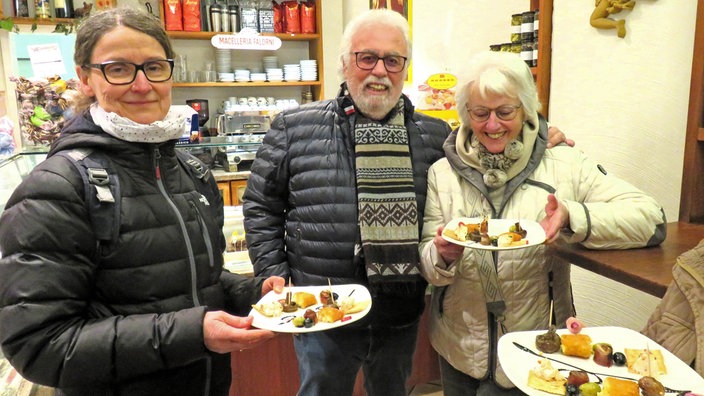 Drei Personen in einem Bistro mit gefüllten Tellern