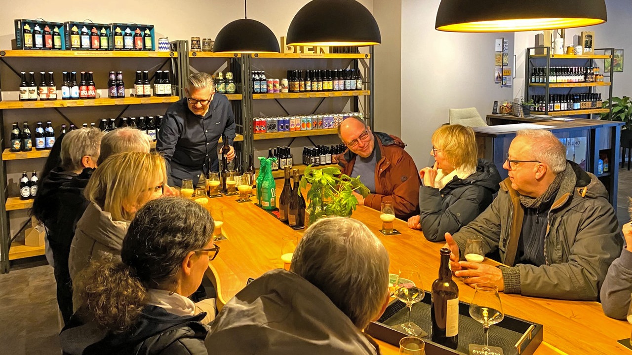 Mehrere Gäste sitzen bei einem Bier-Tasting am Tisch