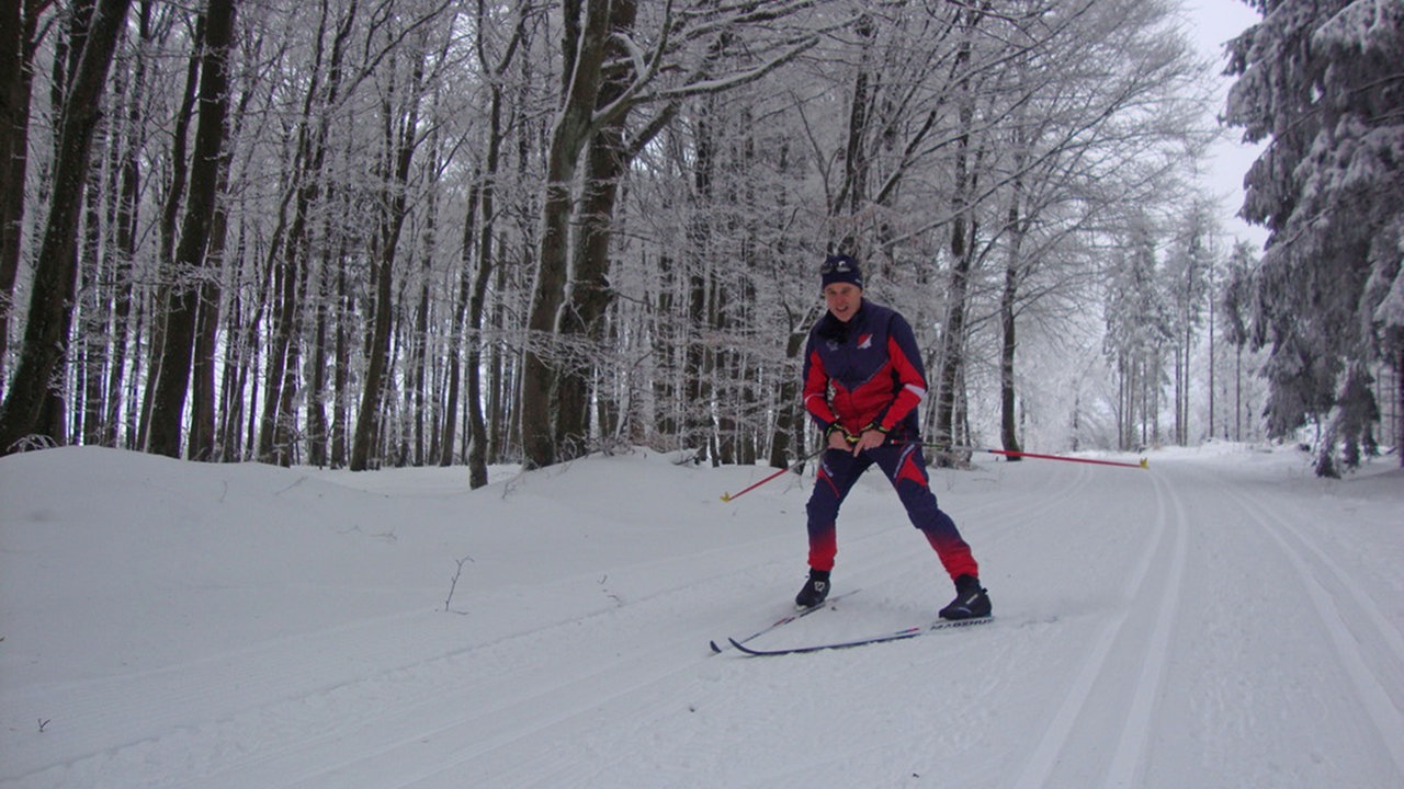 Langlauf der Extraklasse: Langlauffahrer von vorne auf Schnee-Strecke