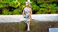 Bronze-Figur auf einer Steinmauer des Märchenmuseums Bad Oeynhausen